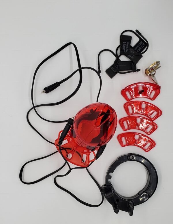 Red chastity cage with wired stimulation device and adjustable components on a white background.