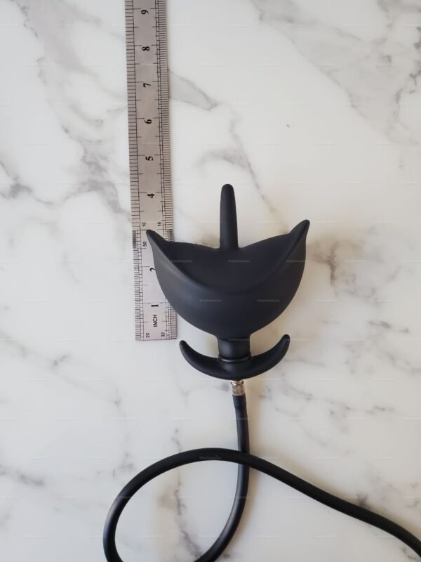 Black inflatable anal expander plug with a sleek design, shown on a marble surface next to a ruler for size reference.
