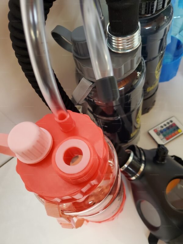 A close-up of a kink bubble bottle with a hose connection and integrated light, featuring a vibrant red cap and sleek black tubing.