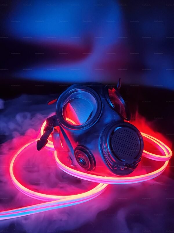 A sleek rubber mask with a front radiator design, surrounded by vibrant neon lights, creating an edgy and futuristic vibe.