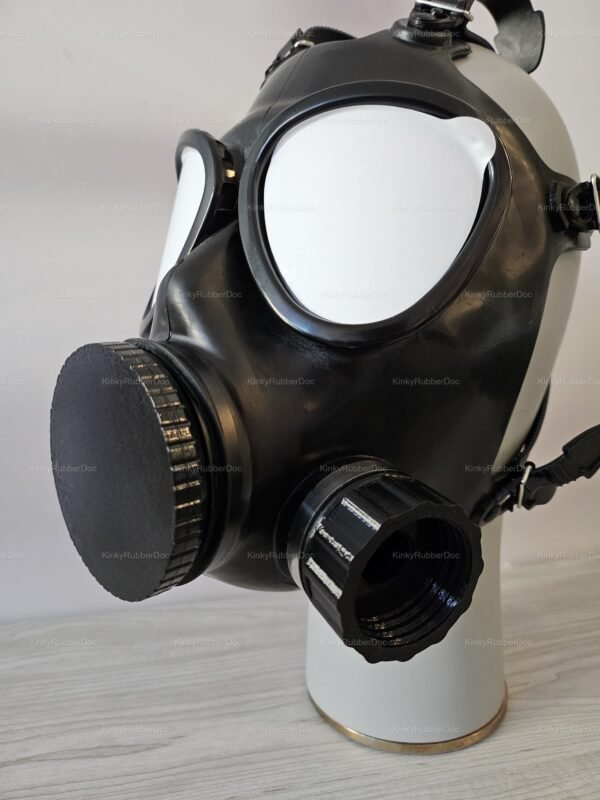 A black rubber mask with distinctive white eye lenses and a unique valve system, part of the mf11-mask-lid-cap-valve-opener-set.