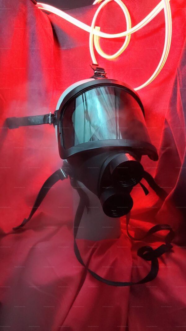 A sleek, modern gas mask with a rubber hood and tinted visor, set against a dramatic red backdrop.