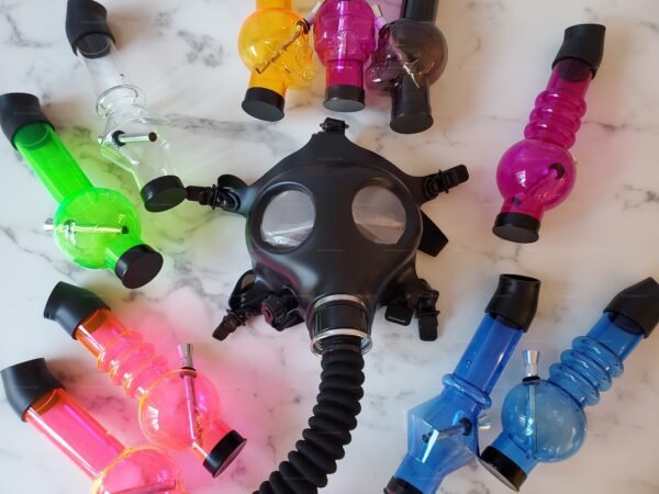 A collection of vibrant, multi-color hookah pipes with a sleek black gas mask attachment on a marble background.