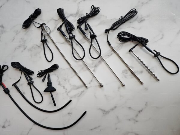 A collection of sleek, metallic penile electrostimulation catheter plug sets in various designs, featuring smooth and textured surfaces with attached cords.