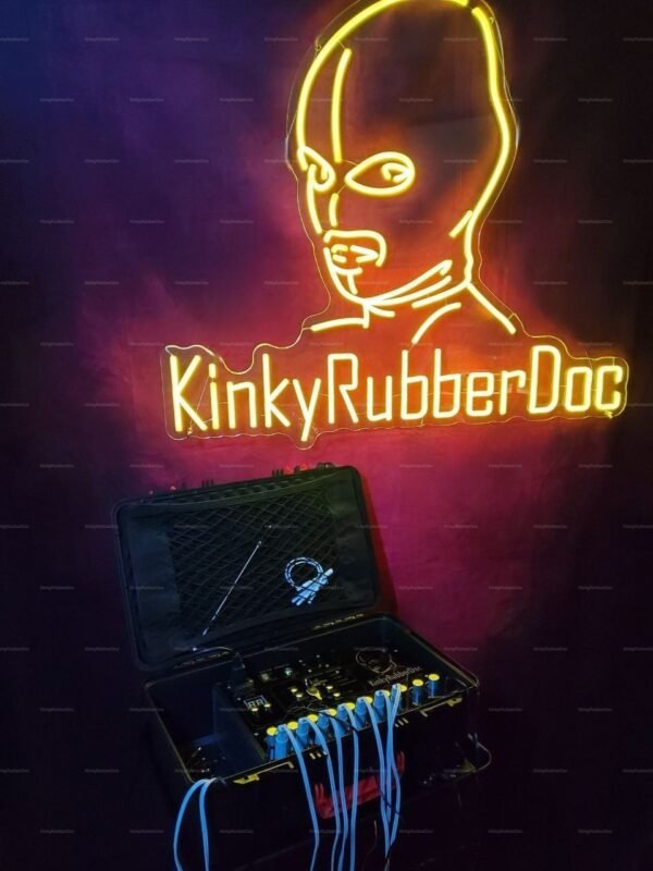 KinkyRubberDoc neon sign above an open case with electronic gear and cables.