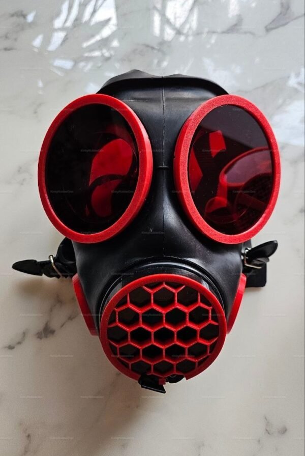 Red and black gas mask with honeycomb front filter and tinted lenses.