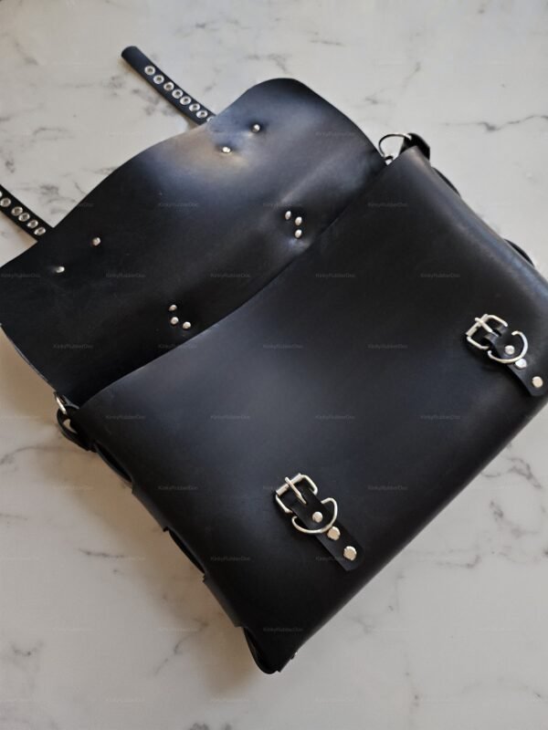A sleek black silicone rubber bag with silver buckle accents and adjustable straps, exuding a bold and edgy aesthetic.