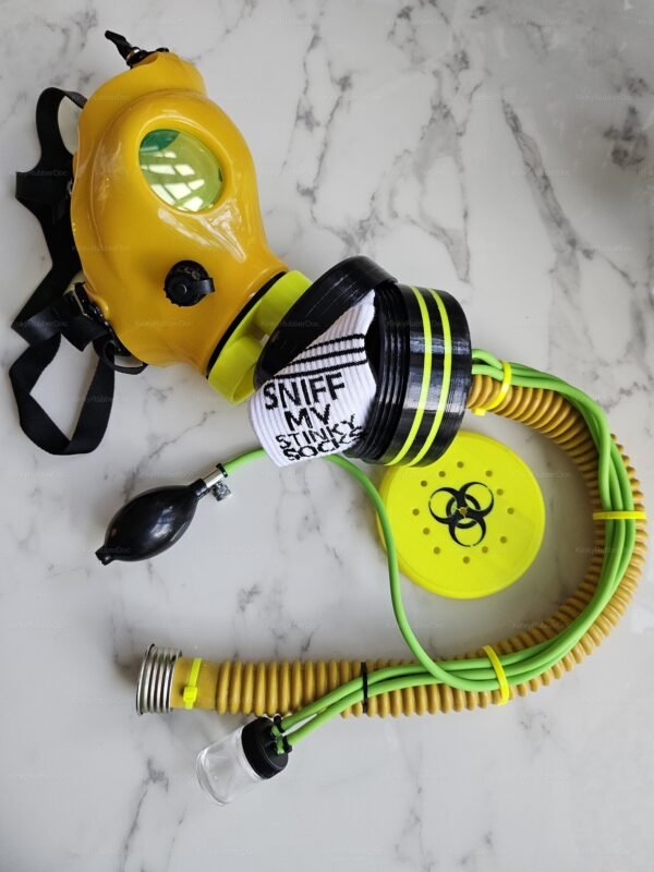 A vibrant yellow gas mask with green-tinted lenses and an attached hose extension, featuring black and neon green accents, designed for immersive fetish play.